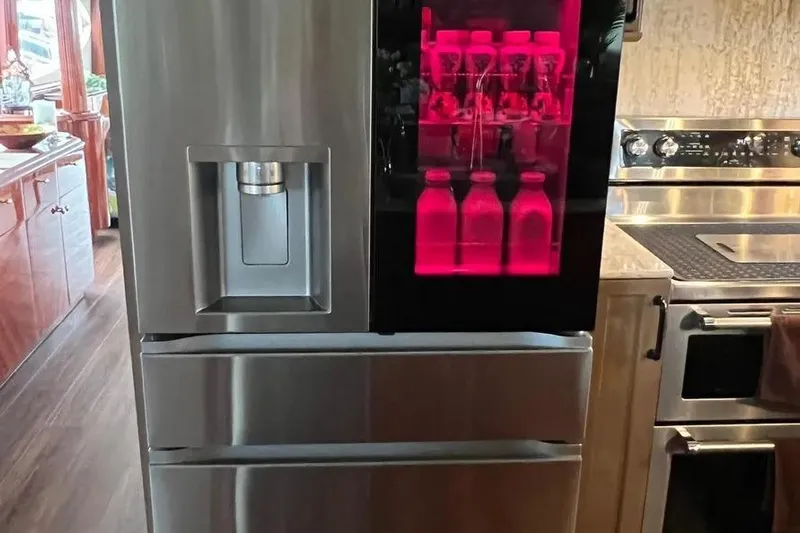  Yacht Photos Pics Modern kitchen with stainless steel refrigerator, red-lit beverage section, aboard 2004 Lazzara SC Motor Yacht.