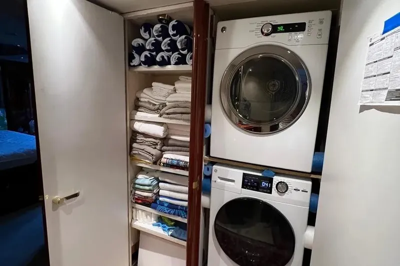  Yacht Photos Pics Laundry area with stacked washer and dryer, neatly organized towels on Lazzara SC Motor Yacht 2004.