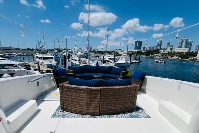  Yacht Photos Pics 2004 Lazzara SC Motor Yacht deck with blue seating, overlooking marina and city skyline.