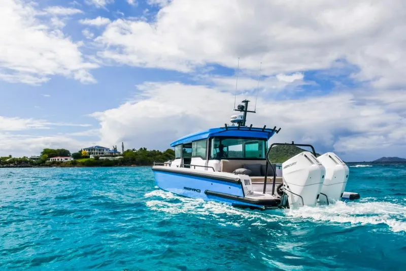  Yacht Photos Pics 2024 Axopar 37XC CROSS CABIN cruising on turquoise waters under a partly cloudy sky.