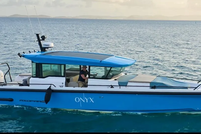  Yacht Photos Pics 2024 Axopar 37XC CROSS CABIN boat on water, featuring blue exterior and modern design.