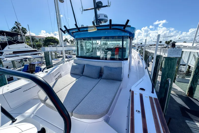  Yacht Photos Pics 2024 Axopar 37XC CROSS CABIN boat docked, featuring spacious sunbed and modern design.