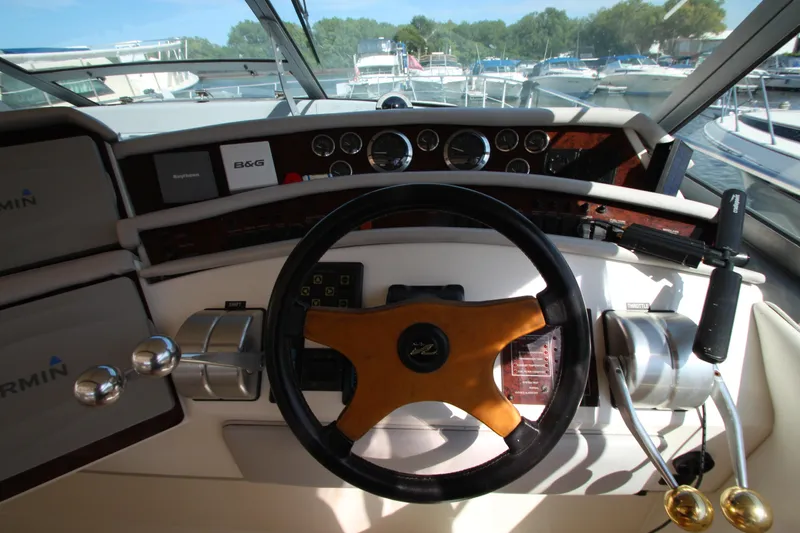  Yacht Photos Pics 1994 Sea Ray 500 Sundancer helm with wooden steering wheel and modern navigation instruments.