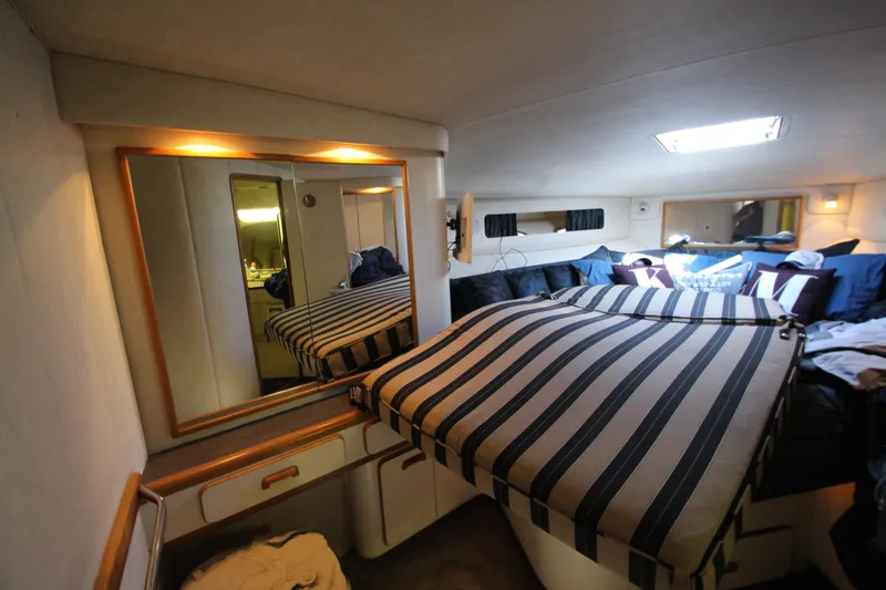  Yacht Photos Pics Luxurious cabin interior of 1994 Sea Ray 500 Sundancer yacht with striped bedding.