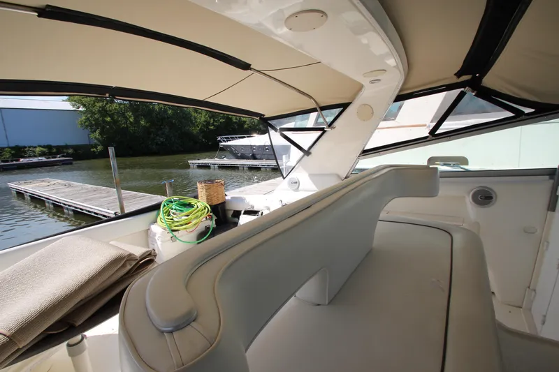  Yacht Photos Pics Interior view of 1994 Sea Ray 500 Sundancer yacht at dock, featuring seating and canopy.
