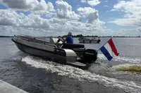 2018 Alufleet Tourer 555 boat on water, Dutch flag, under cloudy sky.