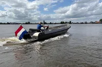 2018 Alufleet Tourer 555 boat cruising on a lake with a Dutch flag.