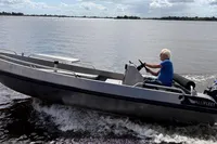 Man driving 2018 Alufleet Tourer 555 boat on a sunny lake.