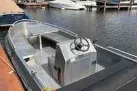2018 Alufleet Tourer 555 boat docked at marina, featuring steering console and seating area.