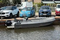 Alufleet Tourer 555 boat docked beside parked cars, featuring a Mercury engine, 2018 model.
