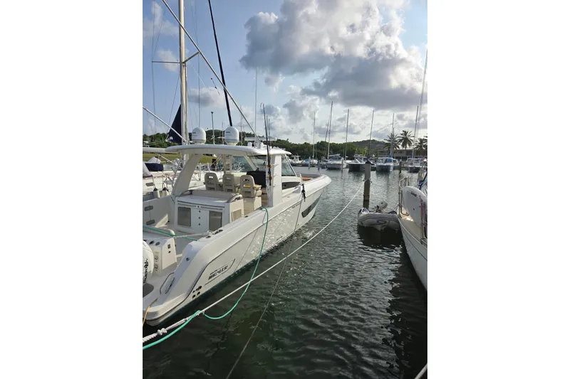  Yacht Photos Pics 2019 Boston Whaler 420 Outrage docked in a marina under cloudy skies.