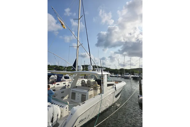  Yacht Photos Pics 2019 Boston Whaler 420 Outrage docked in a marina under a partly cloudy sky.