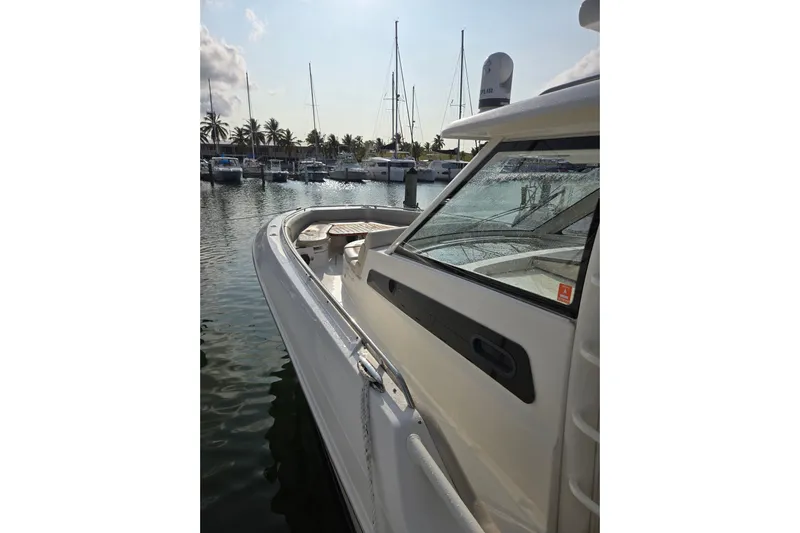  Yacht Photos Pics 2019 Boston Whaler 420 Outrage docked at marina with palm trees and sailboats.