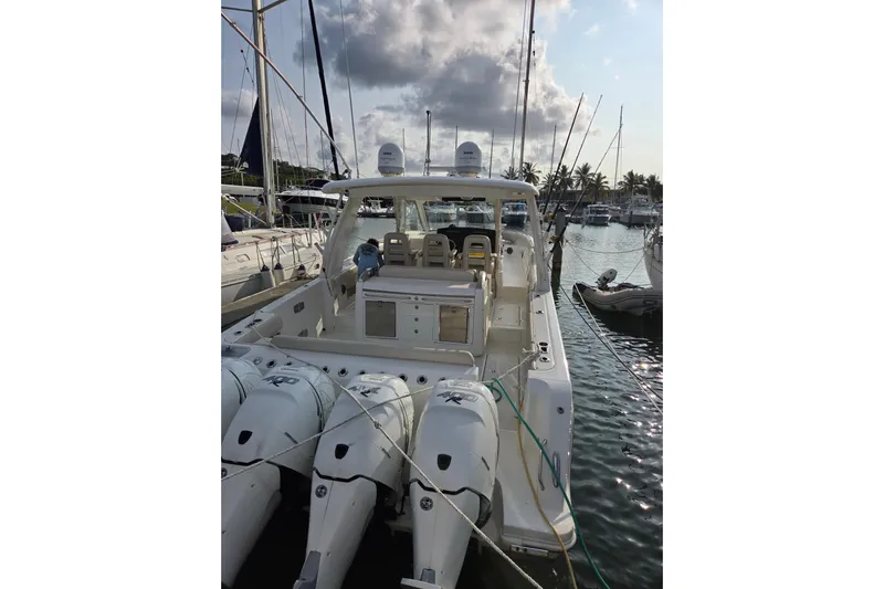  Yacht Photos Pics 2019 Boston Whaler 420 Outrage docked, featuring multiple outboard engines, under a partly cloudy sky.