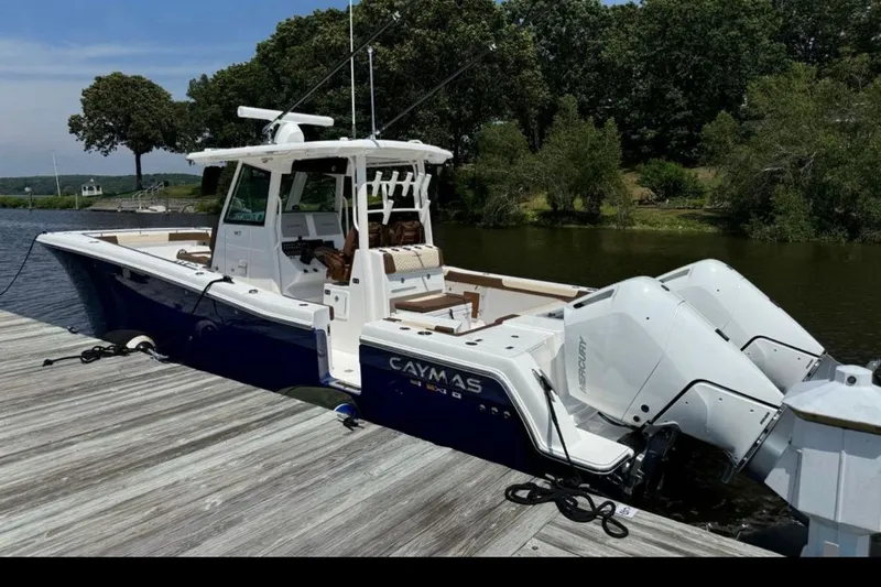  Yacht Photos Pics 2024 Caymas 34 CT boat docked by a scenic riverside with twin Mercury engines.