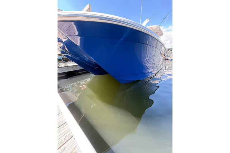  Yacht Photos Pics 2024 Caymas 34 CT boat with blue hull docked in calm water.