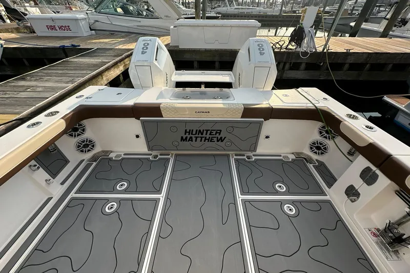  Yacht Photos Pics 2024 Caymas 34 CT boat deck with custom flooring and twin 400 engines at a marina.