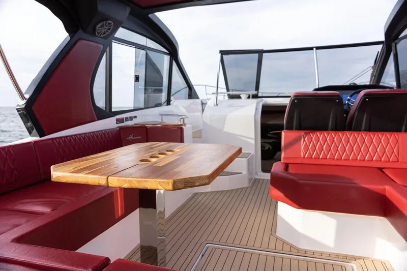  Yacht Photos Pics Luxurious 2026 Hanover 387 yacht interior with red seating and wooden table.