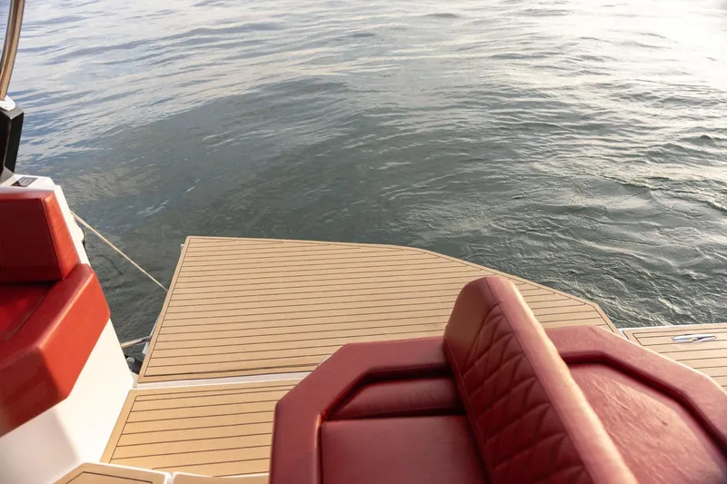  Yacht Photos Pics 2026 Hanover 387 boat with red seating and wooden deck on calm water.