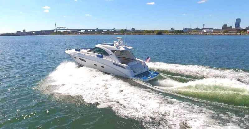 Door V Door Yacht Photos Pics 2011 Sea Ray 470 Sundancer cruising on open water, city skyline in background.