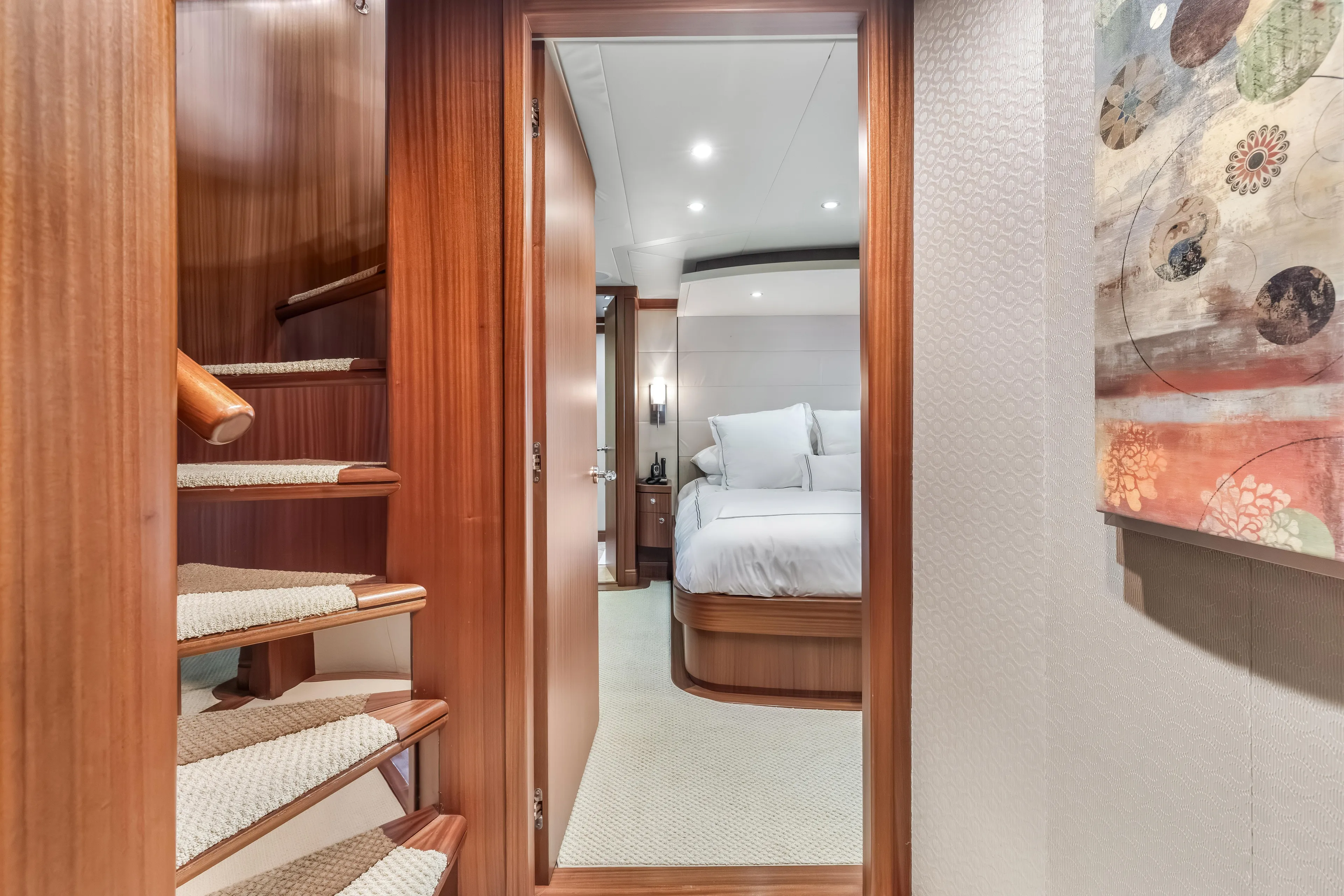 Aurora Yacht Photos Pics Luxurious interior of 2012 Cheoy Lee 84 Bravo yacht, featuring elegant wood staircase and cozy bedroom.