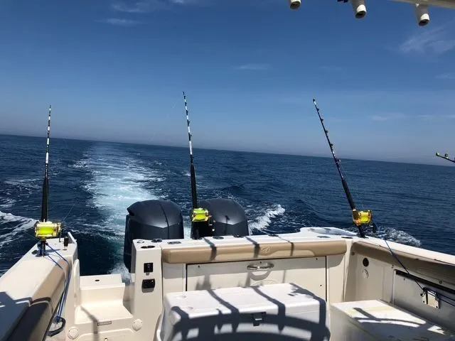  Yacht Photos Pics Sailfish 325 Dual Console 2017 on open sea with fishing rods.