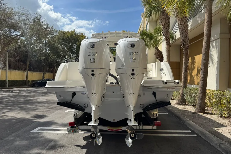  Yacht Photos Pics 2026 Sailfish 312 CC boat with dual outboard engines in a sunny parking lot.