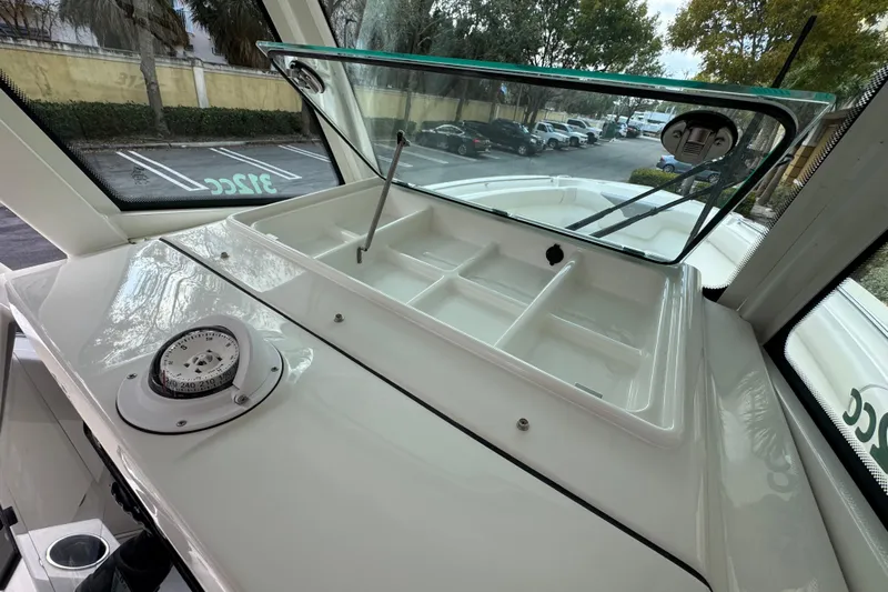  Yacht Photos Pics 2026 Sailfish 312 CC boat dashboard with compass and open storage compartment.