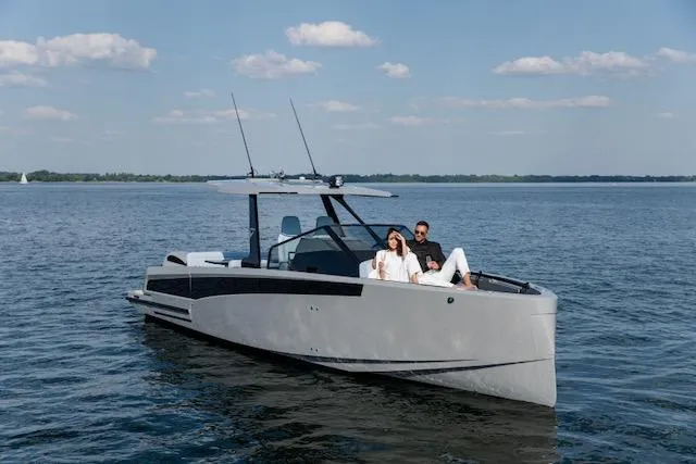  Yacht Photos Pics 2026 Virtue V10 T-Top boat on calm water with two people relaxing onboard.