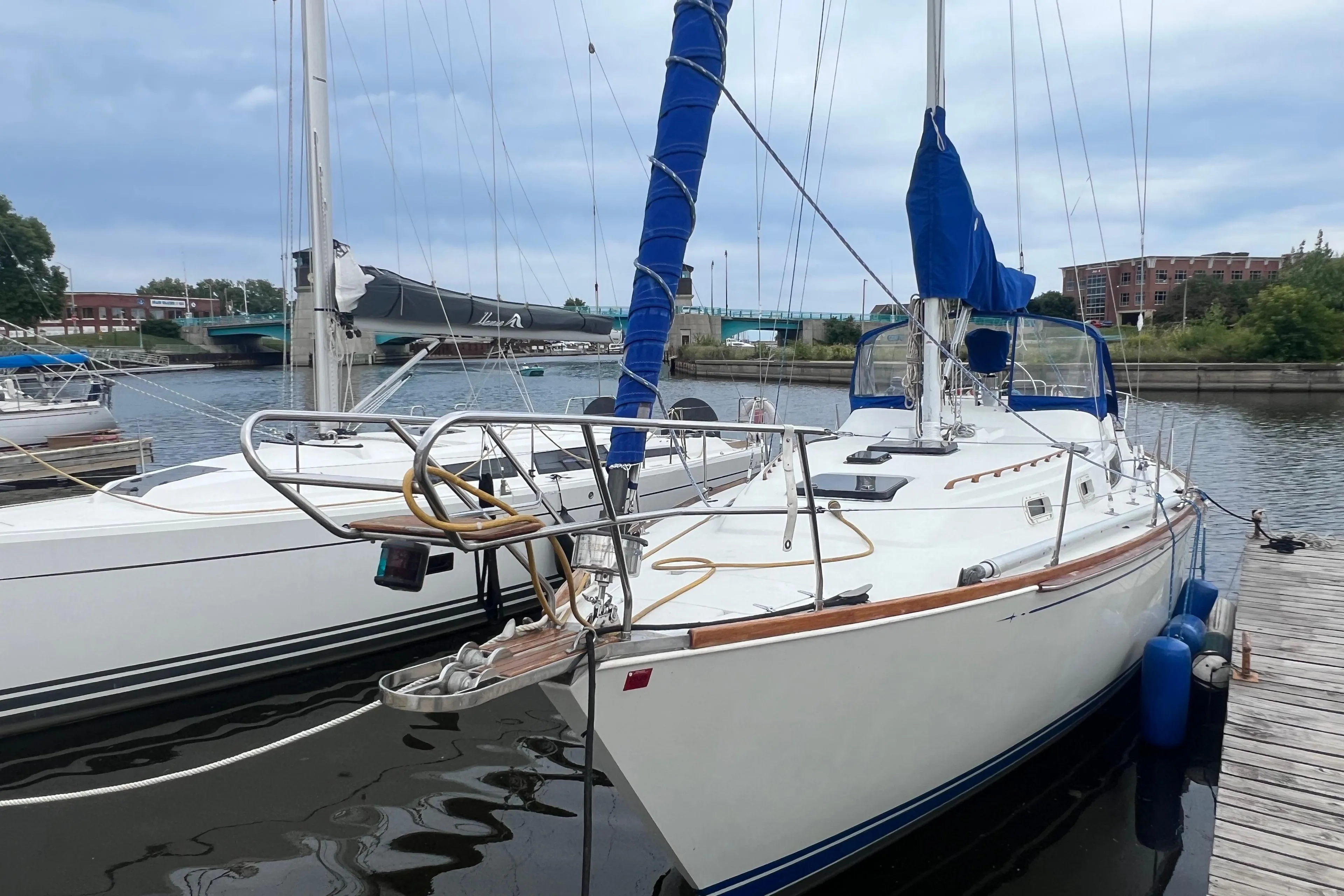 1985 C&C Landfall 39 sailboat docked at marina, featuring blue sail covers.