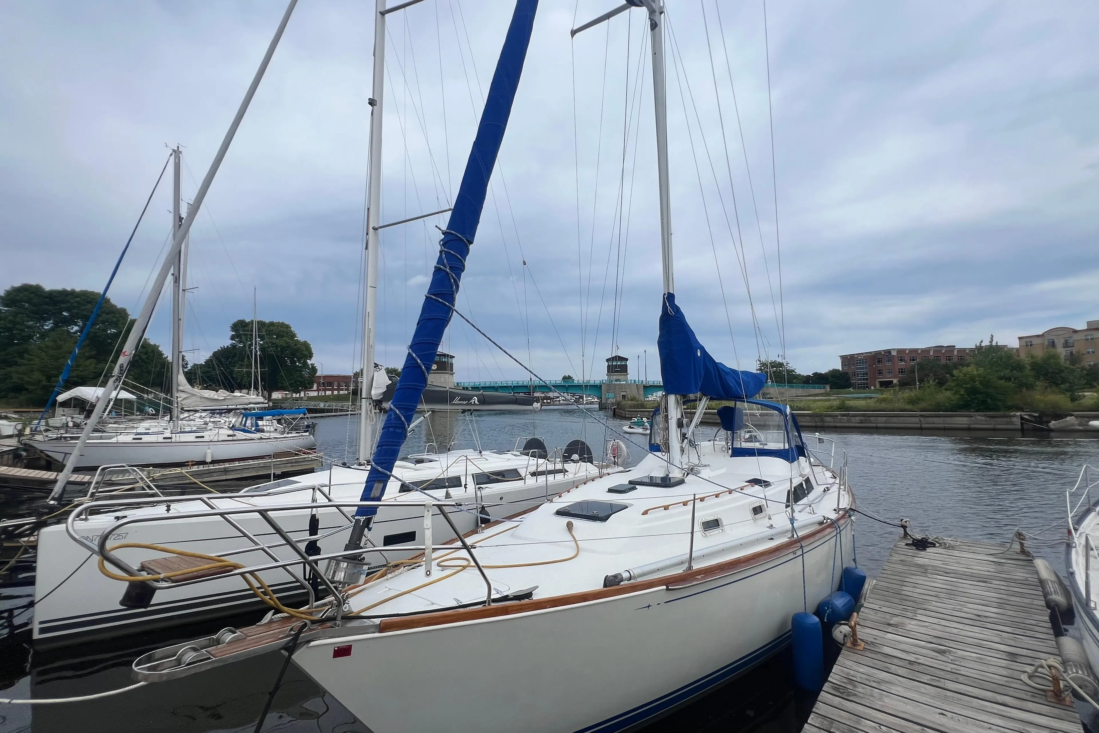 1985 C&C Landfall 39 sailboat docked at a marina with blue sail covers.