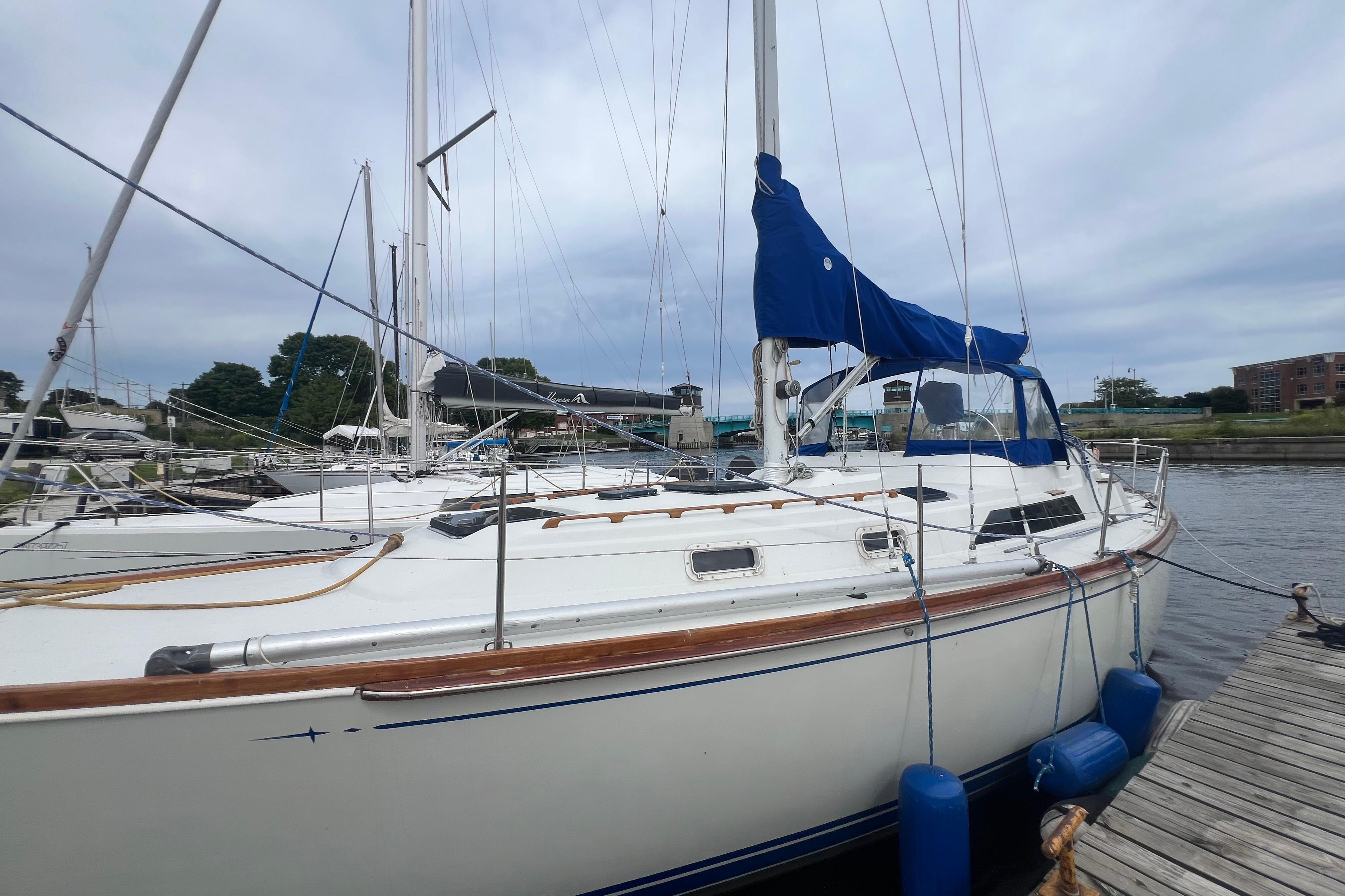 1985 C&C Landfall 39 sailboat docked at marina with blue sail cover.