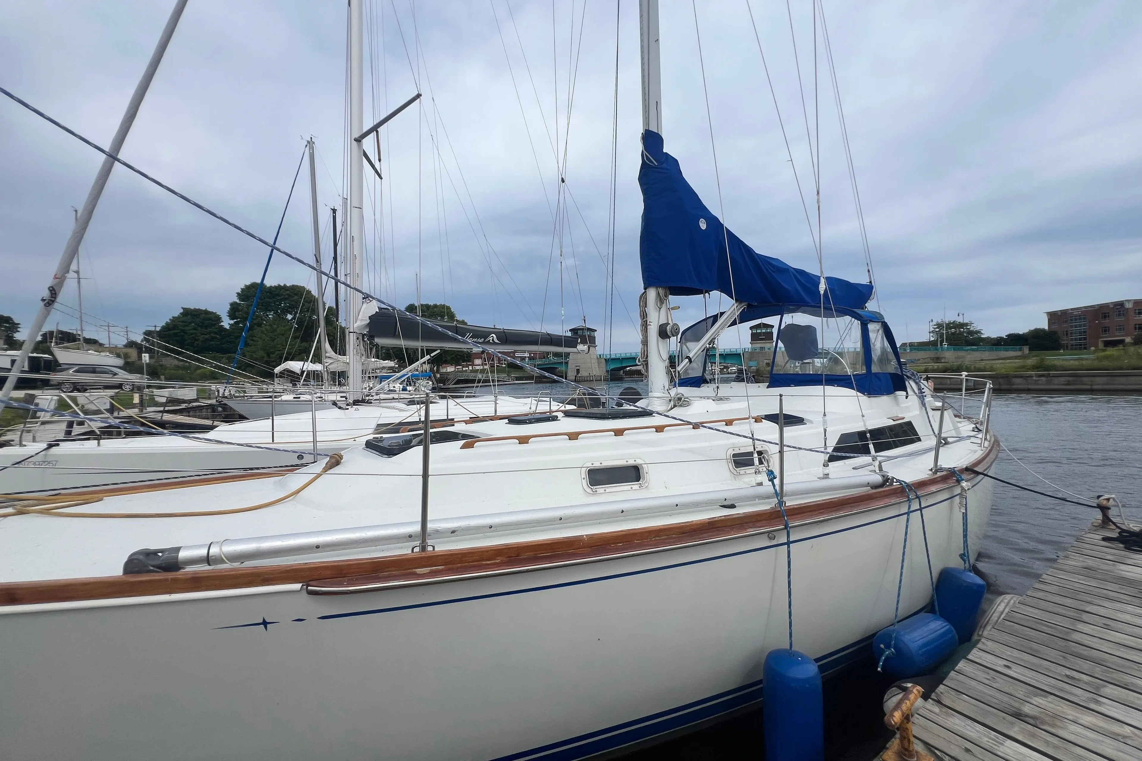 1985 C&C Landfall 39 sailboat docked at marina with blue sail cover.