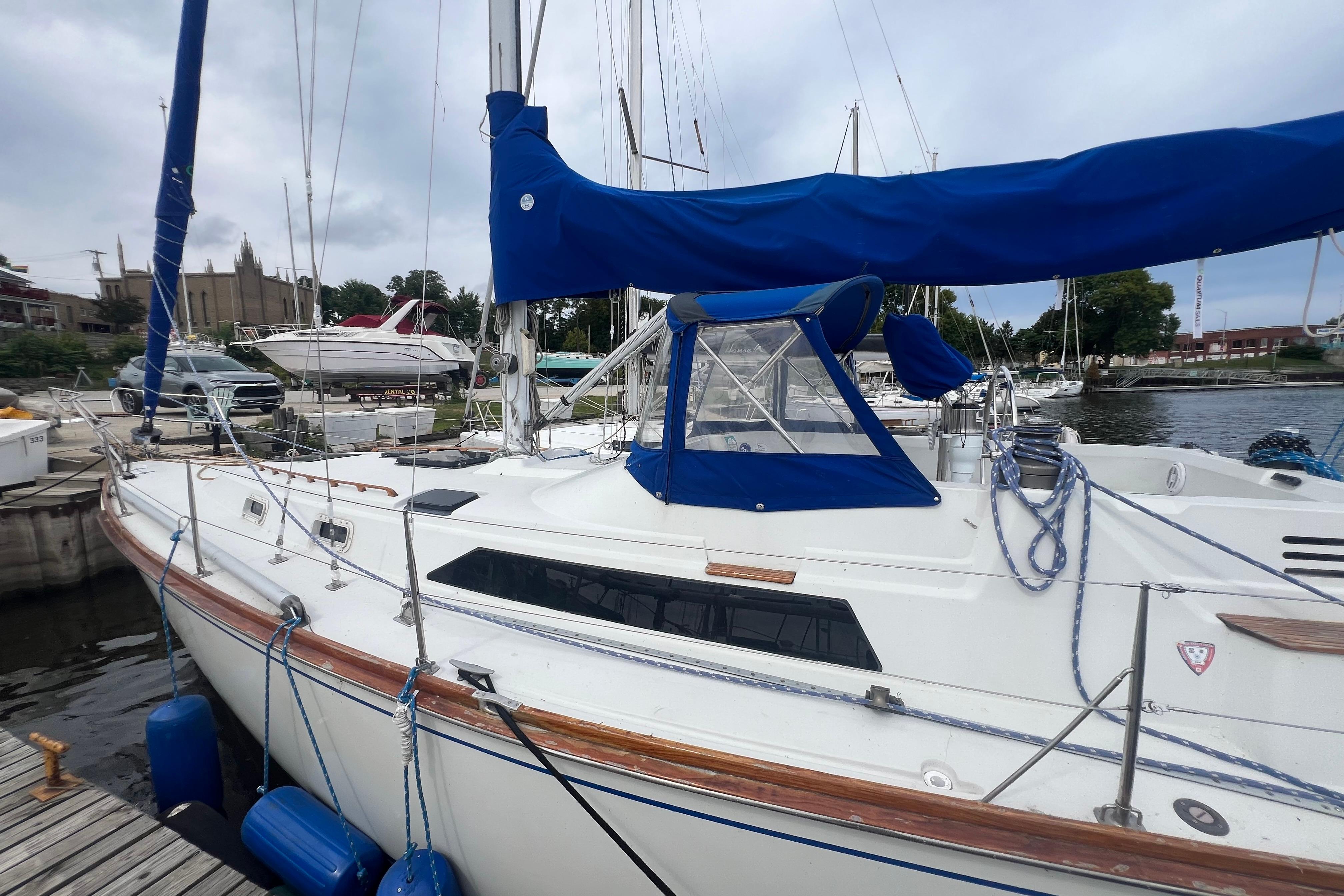 1985 C&C Landfall 39 sailboat docked with blue covers and ropes.