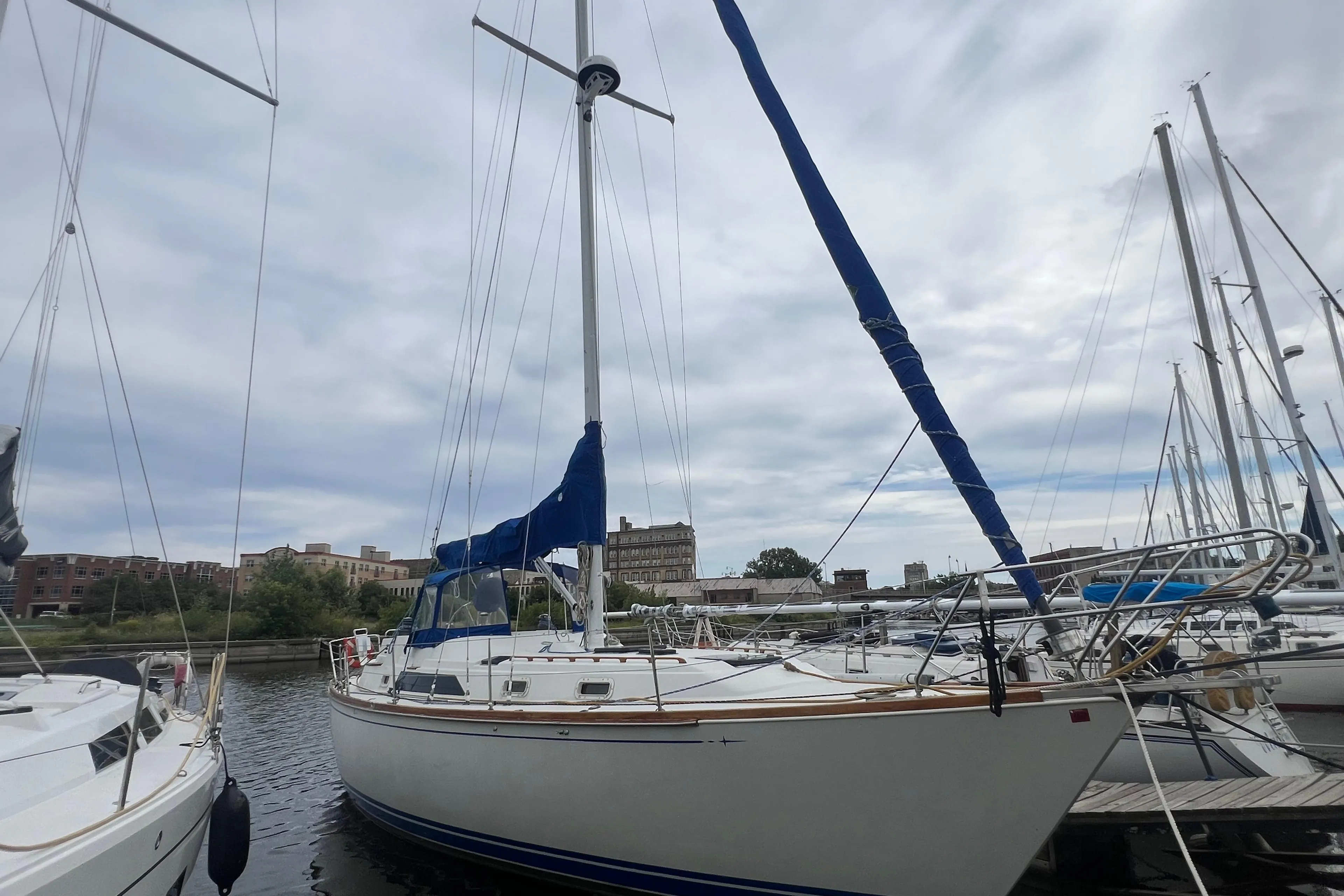 1985 C&C Landfall 39 sailboat docked at a marina under cloudy skies.