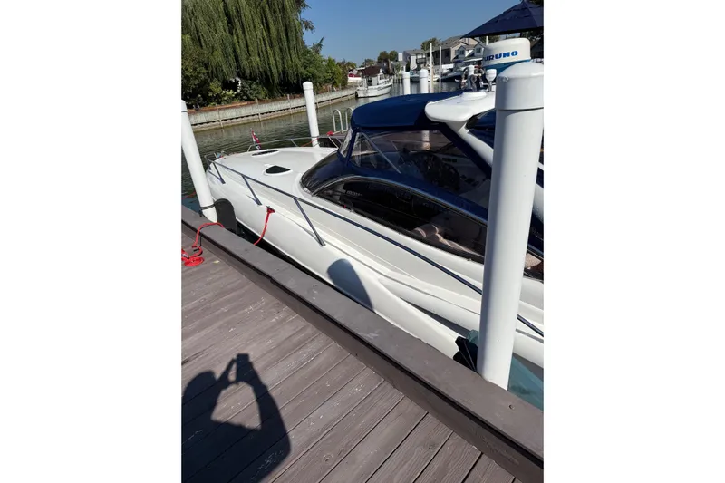 007 Yacht Photos Pics Sunseeker Superhawk 34 yacht docked at marina, 2000 model, sleek white design.