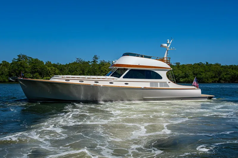 Vera North Yacht Photos Pics 2021 Hinckley Talaria yacht cruising on a sunny day with lush greenery in the background.