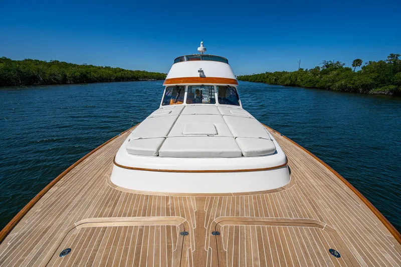 Vera North Yacht Photos Pics 2021 Hinckley Talaria yacht cruising on a serene river with clear blue skies.