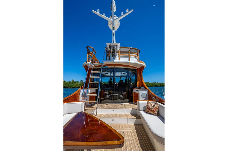 Vera North Yacht Photos Pics 2021 Hinckley Talaria yacht with elegant deck and seating, under clear blue sky.