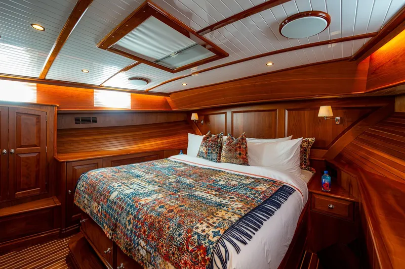Vera North Yacht Photos Pics Luxurious 2021 Hinckley Talaria yacht cabin with elegant wood paneling and cozy bedding.