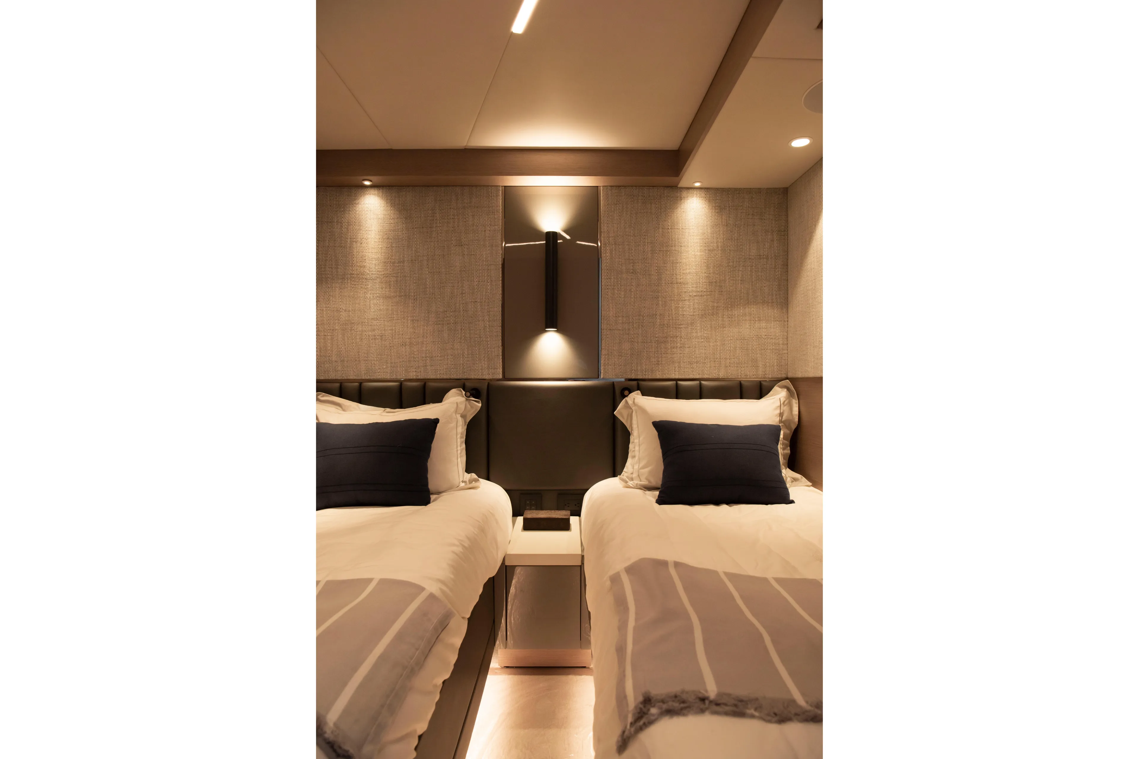 Gaia Yacht Photos Pics Luxurious twin bedroom in 2022 Sunseeker Manhattan 68 yacht, featuring elegant lighting and decor.