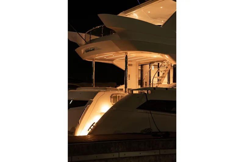 Gaia Yacht Photos Pics Illuminated Sunseeker Manhattan 68 yacht at night, showcasing elegant design, 2022 model.
