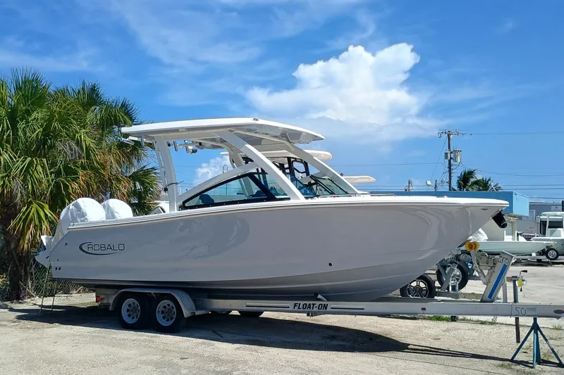 257-155 Yacht Photos Pics 2025 Robalo R257 Dual Console boat on trailer, parked outdoors under blue sky.