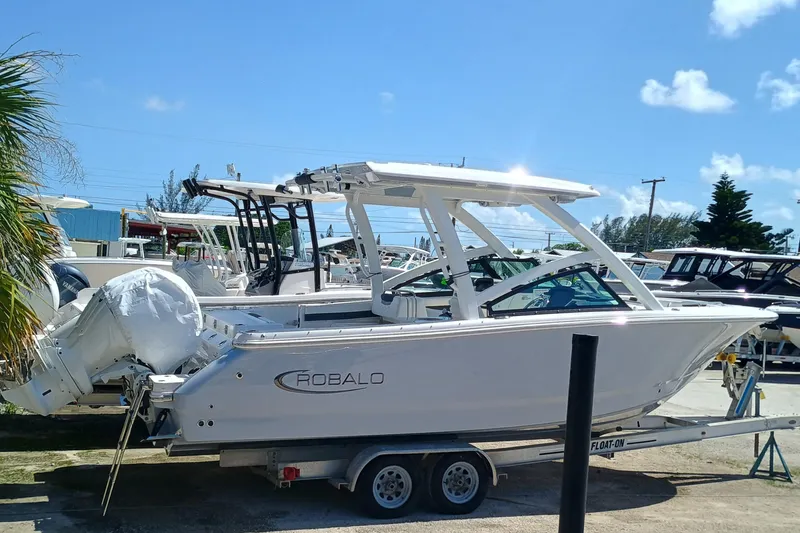 257-155 Yacht Photos Pics 2025 Robalo R257 Dual Console boat on trailer, sunny day, marina background.