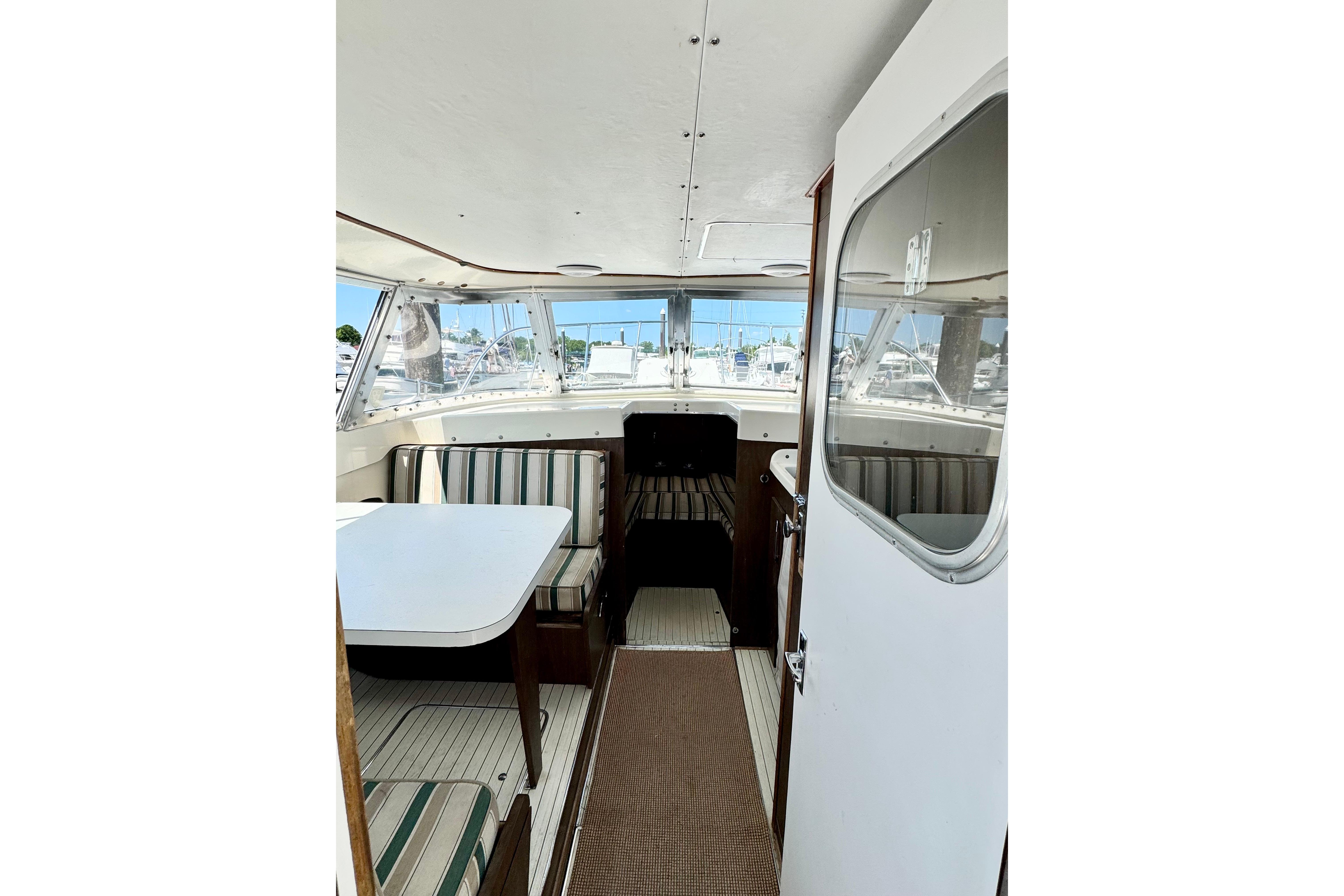Interior of a 1973 Bertram 31 Flybridge Cruiser with striped seating and table.