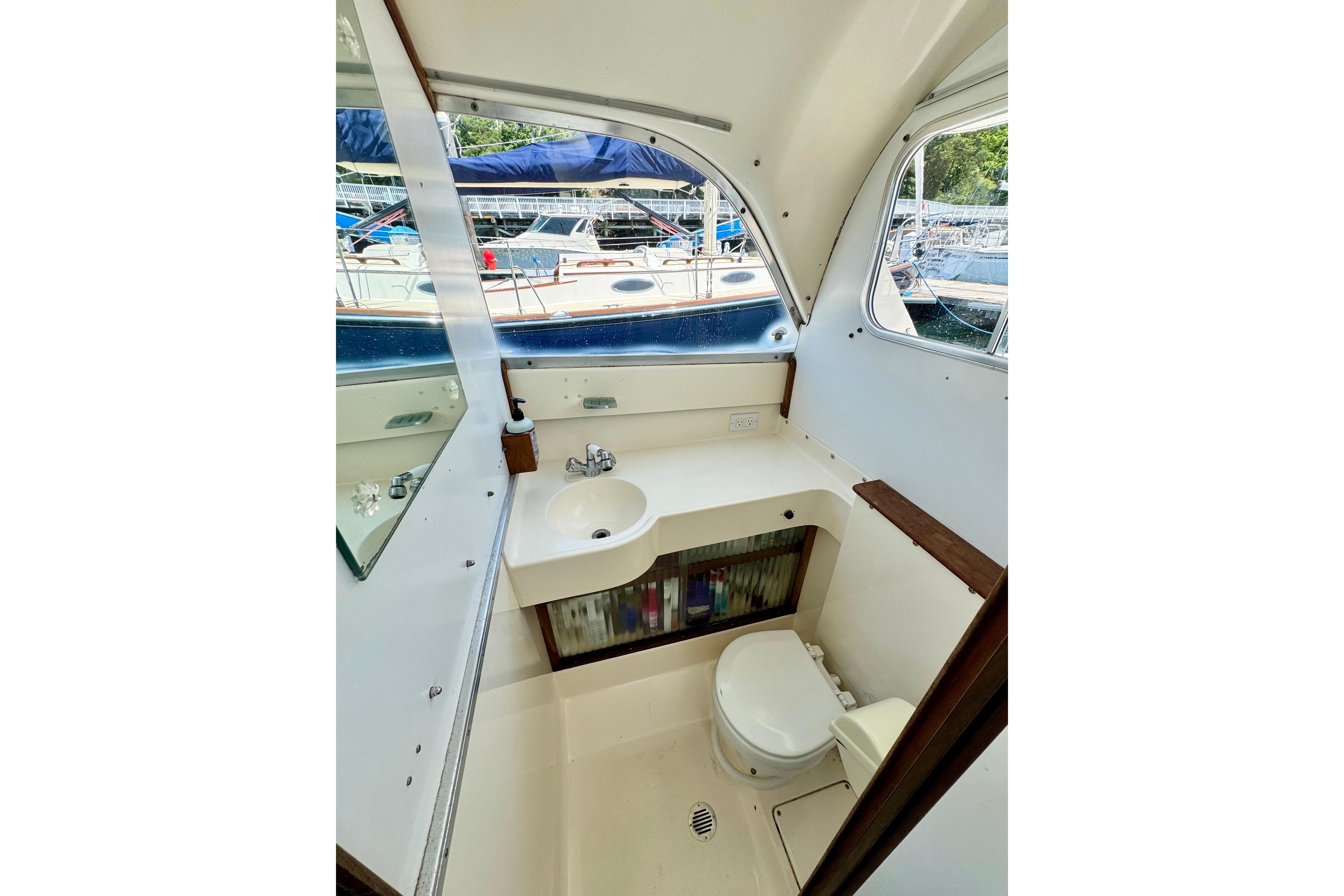 Interior of 1973 Bertram 31 Flybridge Cruiser bathroom with sink and toilet.