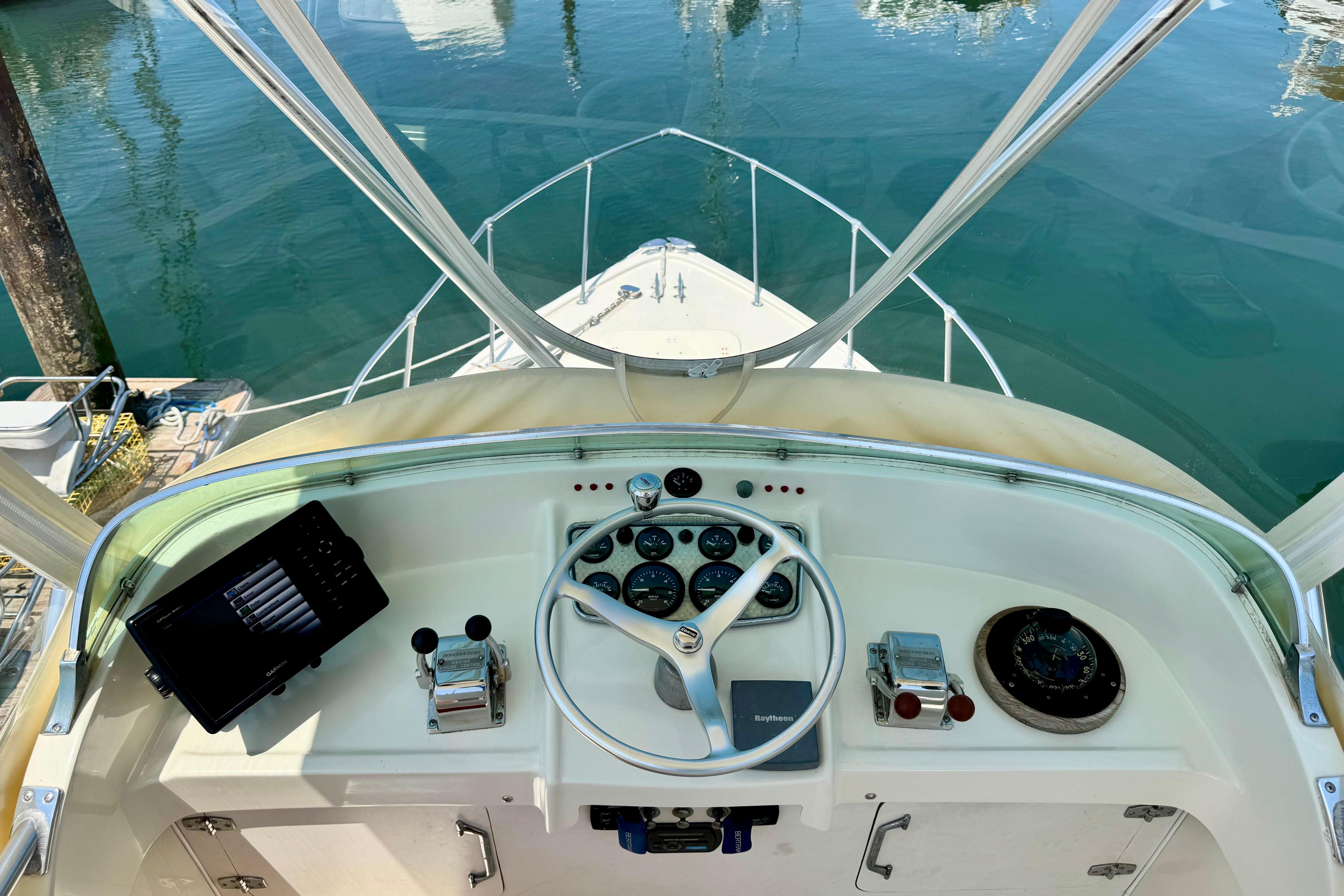 1973 Bertram 31 Flybridge Cruiser helm with steering wheel and navigation instruments.