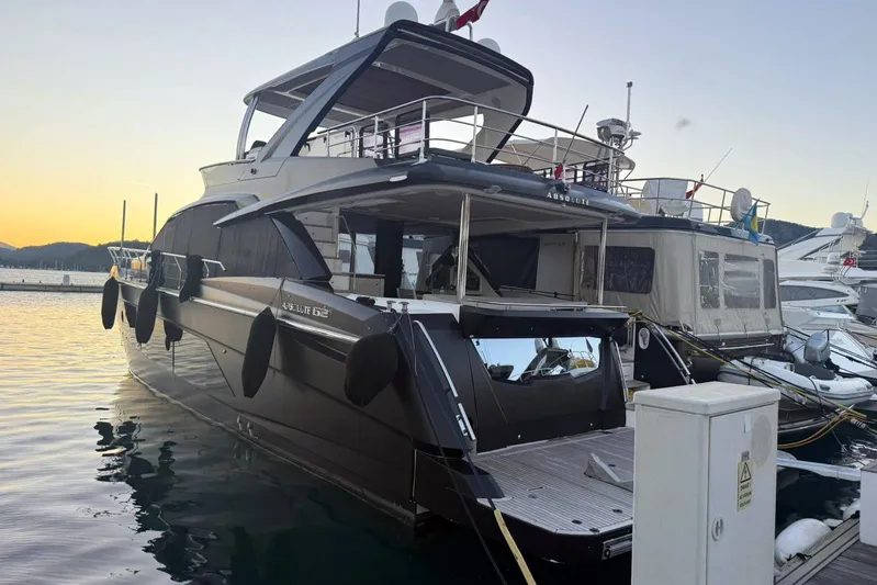3775 Yacht Photos Pics Luxury 2019 Absolute 62 Fly yacht docked at sunset, showcasing sleek design and elegance.