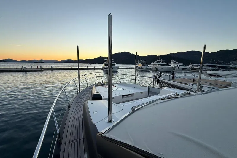 3775 Yacht Photos Pics 2019 Absolute 62 Fly yacht docked at sunset, surrounded by serene waters and distant hills.