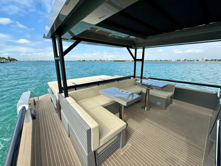  Yacht Photos Pics Luxurious 2023 De Antonio Yachts D50 Coup&eacute; deck with seating, overlooking serene blue waters.